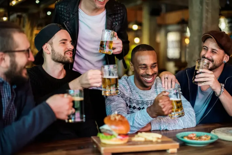 Group of men enjoying drinks and food at bar