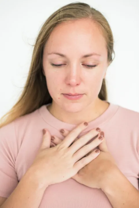 Portrait of a sad woman a woman resting her hands gently on her heart. 