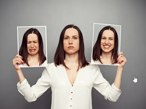 A woman holding a picture of herself crying on her right and a picture of herself smiling on her right.