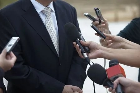 Microphones in front of the chest of a man who looks like a politican